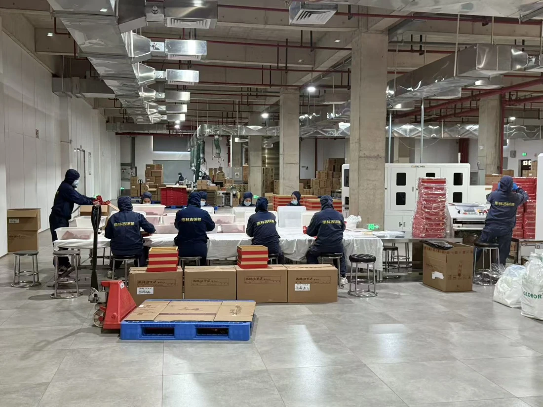 The black-tea production line. From raw material to finished product, the process involves weighing, steaming, shaping, pressing, drying and packaging, combining automation with manual assistance.